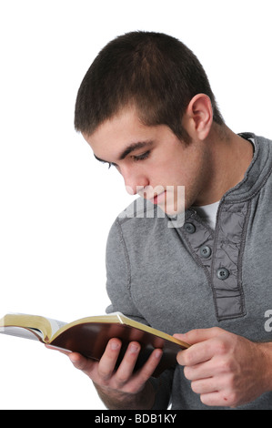 Teen Junge liest die Bibel isoliert auf weiss Stockfoto