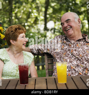 Älteres Paar an einem Tisch sitzen und Lächeln Stockfoto