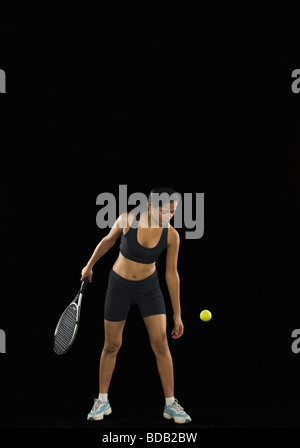 Junge Frau, die Tennis spielen Stockfoto