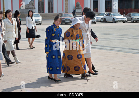 Mongolische Frauen gehen in festlichen Trachten, Sukhbaatar Platz, Ulan Bator, Mongolei Stockfoto