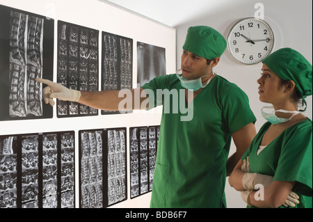 Weibliche Chirurg mit einem männlichen Arzt untersuchen einen Röntgen-Bericht Stockfoto