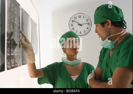 Weibliche Chirurg mit einem männlichen Arzt untersuchen einen Röntgen-Bericht Stockfoto