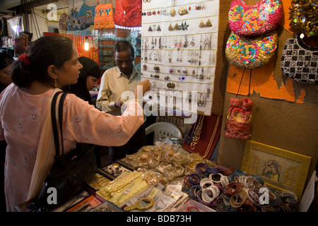 Indische Frau Touristen untersuchen Schmuck zum Verkauf in einem Souvenirgeschäft. Chatta Chowk Markt innerhalb des Roten Forts, Delhi. Indien. Stockfoto