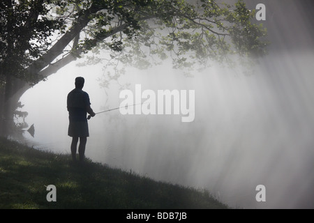 Fliegen Sie Fischer mit Morgennebel und Strahlen der Sonne, auf dem Smith River in Virginia, USA Stockfoto