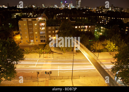 Nächtliche Blick vom verlassenen Gebäude in Elephant & Schloss mit Stadt im Hintergrund und Fußgängerbrücke im Vordergrund Stockfoto