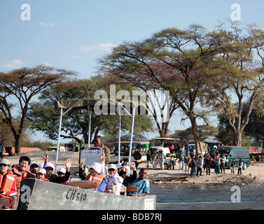 Eine Gruppe von asiatischen Touristen in einem kleinen Boot verlassen Botswana auf der 400m-Kreuzung des Sambesi-Flusses nach Kazungula in Sambia. Stockfoto