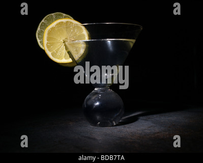 Zitronen und Limetten Scheiben in ein Glas mit gerichtete Beleuchtung. Stockfoto
