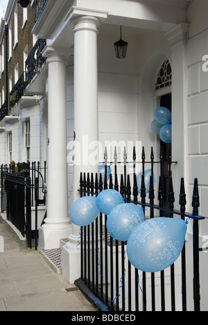 Blaue Luftballons für ein Baby jungen erste Geburtstagsfeier gebunden vor der Tür und Geländer außerhalb Haus London UK Stockfoto