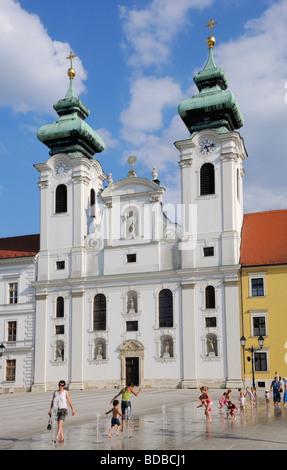 Gyor, W Transdanubien Ungarn. St. Ignatius Benediktinerkirche Szechenyi ter.  Kinder spielen im Brunnen (2009 installiert) Stockfoto