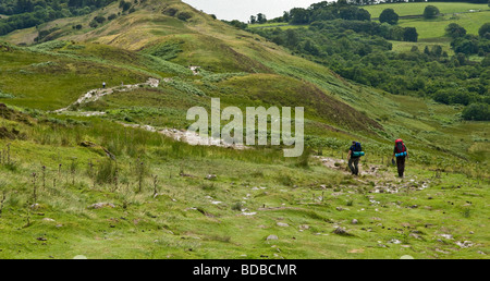 zwei männliche Wanderer zu Fuß nach unten von der Oberseite der Conic Hill sieht über Loch Lomond in Schottland. Stockfoto