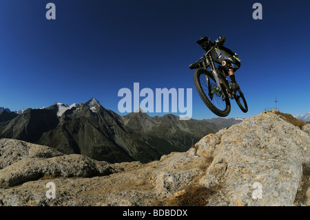 Ein Mountainbiker reitet einen felsigen downhill-Strecke entlang einer Kante hoch über Pila in den italienischen Alpen. Stockfoto
