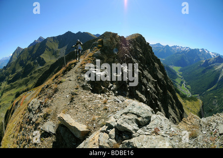 Ein Mountainbiker reitet einen felsigen downhill-Strecke entlang einer Kante hoch über Pila in den italienischen Alpen. Stockfoto