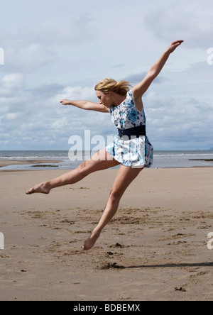 Frau am Strand tragen eine altmodische geblümten Kleid tanzt Stockfoto