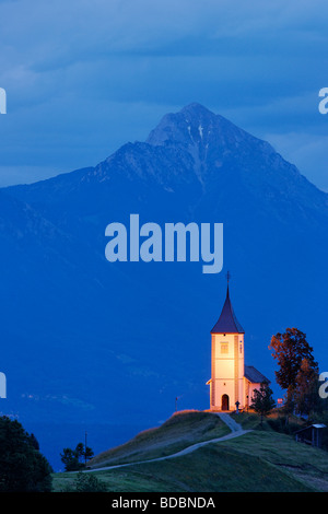 Die Kirche St Primoz in der Nähe von Jamnik und Kroper, Gorenjska, Slowenien. Storzic Berg hinter. Stockfoto