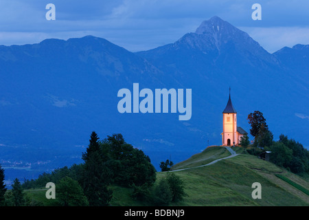 Die Kirche St Primoz in der Nähe von Jamnik und Kroper, Gorenjska, Slowenien. Storzic Berg hinter. Stockfoto