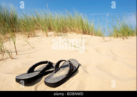 Paar Sandalen an einem sonnigen Sommertag am Strand zwischen Dünen in Norfolk Stockfoto