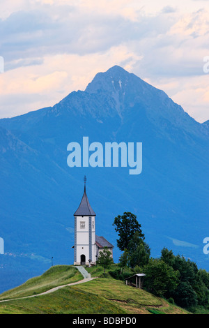 Die Kirche St Primoz in der Nähe von Jamnik und Kroper, Gorenjska, Slowenien. Storzic Berg hinter. Stockfoto