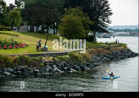 Ein Kajakfahrer Paddel Laurel Point Park in Victorias Innenhafen Bereich vorbei auf Vancouver Island, British Columbia, Kanada. Stockfoto