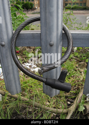 Zyklus-Diebstahl Fahrrad Kabelschloss am Sicherheitszaun geschnitten Stockfoto