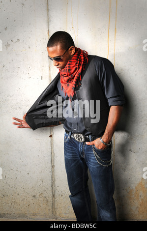 Afrikanische amerikanische Hip-Hop-Man zieht Weste über einem Grunge Hintergrund Stockfoto