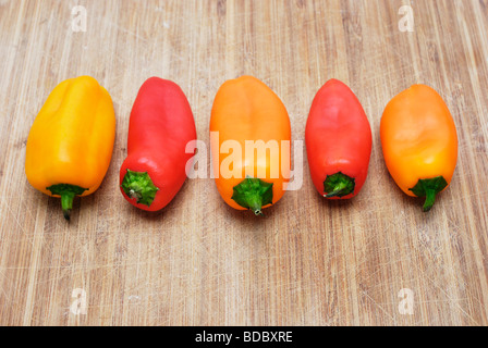 Bunte Süße Baby Paprika Paprika auf ein Schneidbrett aus Holz angeordnet Stockfoto