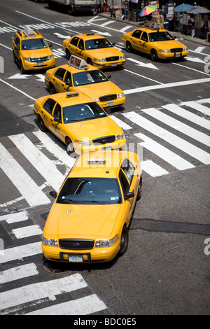 Sechs gelben Taxis oder mit dem Taxi biegen Sie am Broadway und einen Fußgängerweg überqueren, wie Eintreffen von einem sonnigen Tag am Time Square in New York Stockfoto