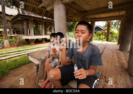 Indonesien Sulawesi Tana Toraja Bebo junge Dorfjunge Seifenblasen im Schatten der Tongkonans Haus Stockfoto