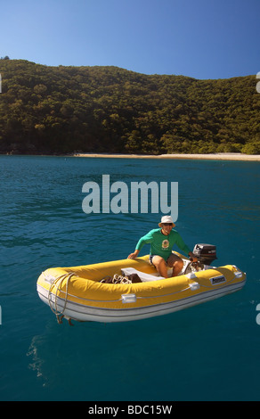 Mann treibende gelbe Schlauchboot in Maureen es Cove, Hook Island, Whitsunday Islands Nationalpark, Queensland, Australien Stockfoto