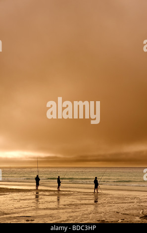 Drei Angler Strand Angeln bei Sonnenuntergang in Sennen in Cornwall Stockfoto