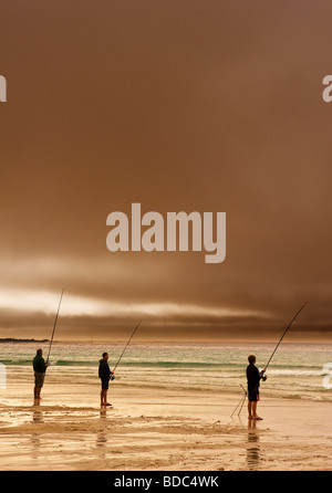 Drei Angler Strand Angeln bei Sonnenuntergang in Sennen in Cornwall. Stockfoto