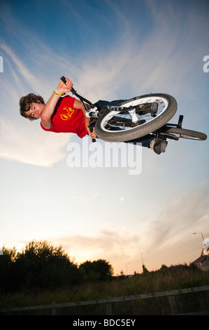 Teenager auf Studien Fahrrad in einem Skateboard-Park Durchführung aerobatische Bremsungen in der Abenddämmerung Aberystwyth Wales UK Stockfoto