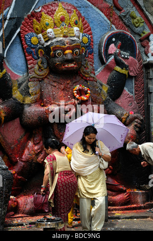 Schwarz Bhairab Statue und Gläubige bieten beten Anbetung Ritual Khal Bhairav Shiva Durbar Square Kathmandu Nepal Stockfoto