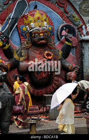 Schwarz Bhairab Statue und Gläubige bieten beten Anbetung Ritual Khal Bhairav Shiva Durbar Square Kathmandu Nepal Stockfoto