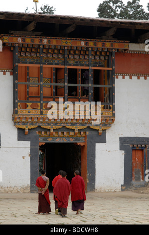 Eingang des Gangtey Gompa, das größte Nyingma-Kloster in Bhutan, mit vier Mönche Stockfoto