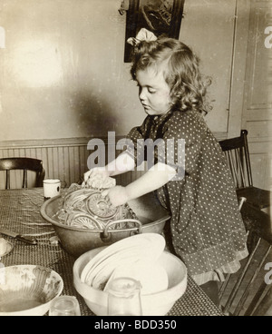 Niedliche kleine blonde Mädchen beim Abwasch Stockfoto