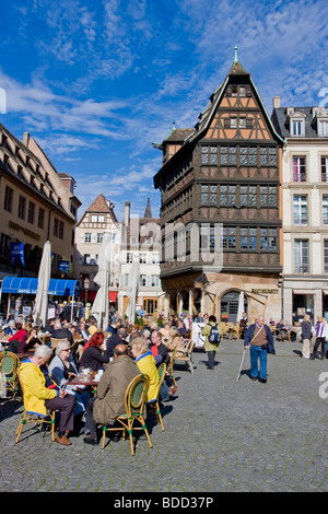 Leute sitzen in Straßencafés am Straßburger Münster Platz in der Nähe von Erbe Haus Kammerzell, Frankreich Stockfoto