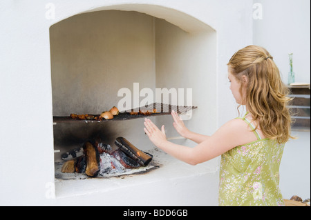 Mädchen Kochen Kebap im Kamin Stockfoto