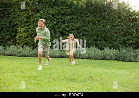 Junge und ein Mädchen in einem Garten spielen Stockfoto