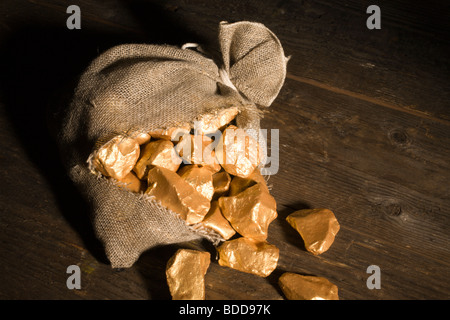 Gold aus einer kaputten Tasche fallen. Stockfoto