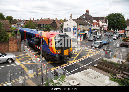 Autos warten, da eine South West Trains s-Bahn ein Bahnübergang in Datchet, Berkshire, UK geht. Stockfoto