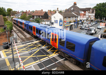 Autos warten, da eine South West Trains s-Bahn ein Bahnübergang in Datchet, Berkshire, UK geht. Stockfoto