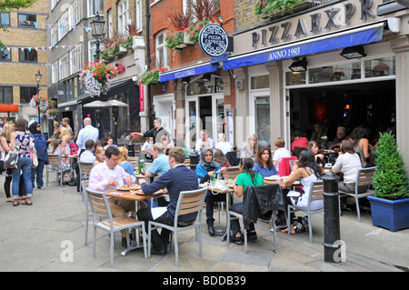 Pizza Express Restaurant, in dem Gäste im St. Christophers Place an der Oxford Street im Sommer im Londoner West End in Großbritannien im Freien speisen können Stockfoto