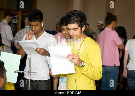 Zwei asiatische männlichen Studenten überprüfen ihre GCSE A-Level-Prüfungsergebnisse ihrer Sixth Form College Stockfoto