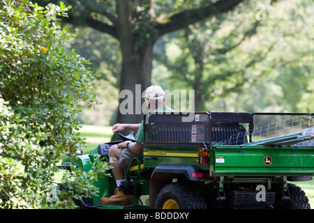 Ein Gärtner mit einer Belastung von Mulch im Bett von einem John Deere Nutzfahrzeug zu vertreiben. Stockfoto