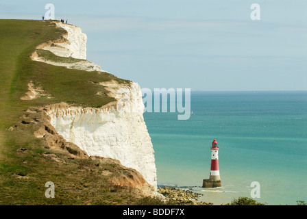 Beachy Head Leuchtturm bemalt rot und weiß, Satz gegen den Ärmelkanal mit dem felsigen Strand im Vordergrund Stockfoto