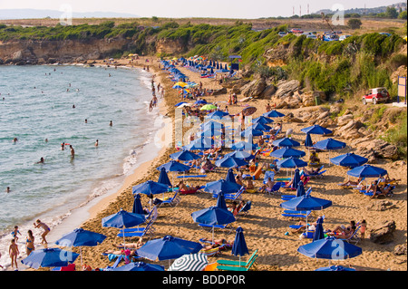 Urlauber, die Sonnenbaden auf einem überfüllten Ammes Beach auf der griechischen Mittelmeer Insel von Kefalonia Griechenland GR Stockfoto