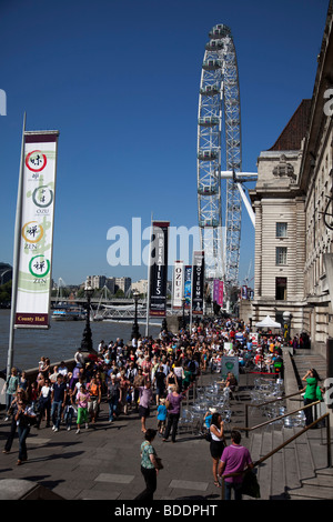 Massen von Touristen versammeln sich entlang der Southbank in der Nähe von London Eye. Dies ist einer der belebtesten Orte für den Tourismus in London. Stockfoto