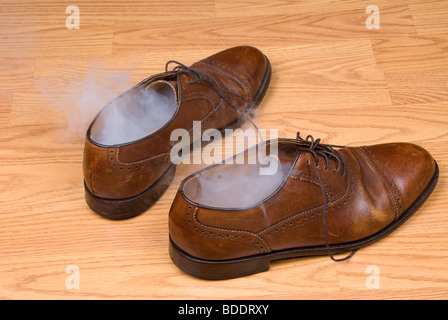 Ein paar Kleidschuhe nach einem heißen Tag Verschleiß dämpfen. Stockfoto