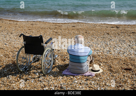 Mann und ein Rollstuhl am Strand von Bognor Regis West Sussex England Südengland Stockfoto