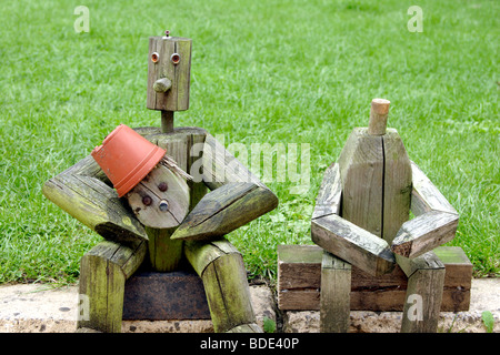 Holzfiguren sitzen in der Nähe von Garten Rasen England UK Stockfoto